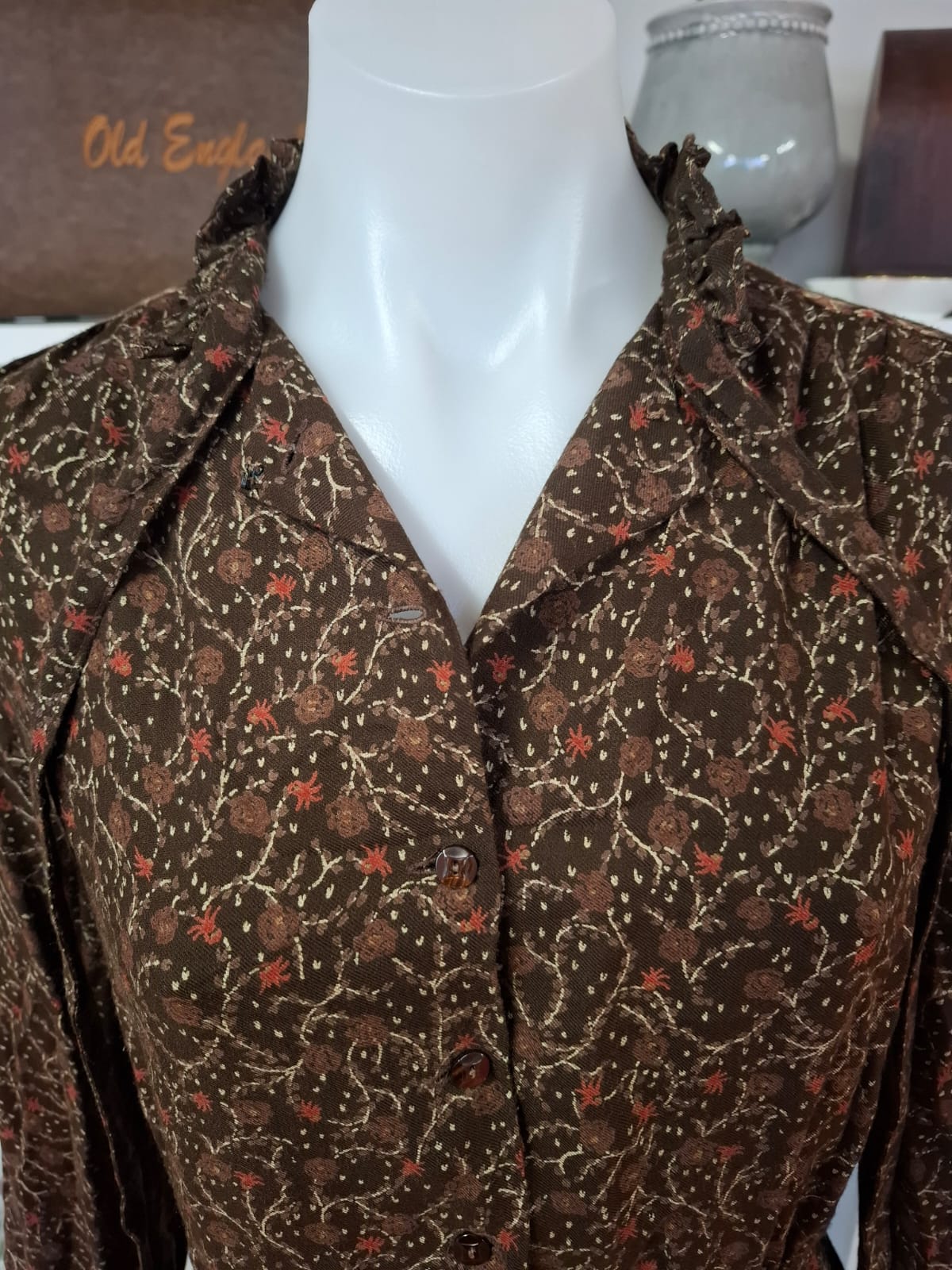 Damon International A division of LEON CUTLER Raffles necline design V-neck. LOng sleeves non stretch with tie on the neck part. Complete buttons down. Semi pleated skirts.