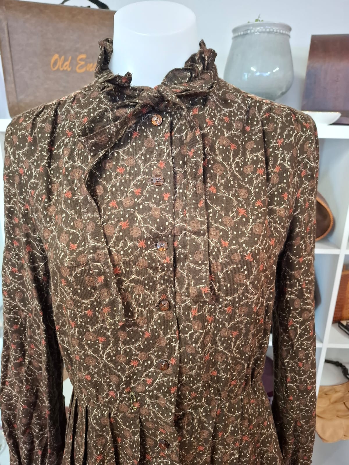 Damon International A division of LEON CUTLER Raffles necline design V-neck. LOng sleeves non stretch with tie on the neck part. Complete buttons down. Semi pleated skirts.