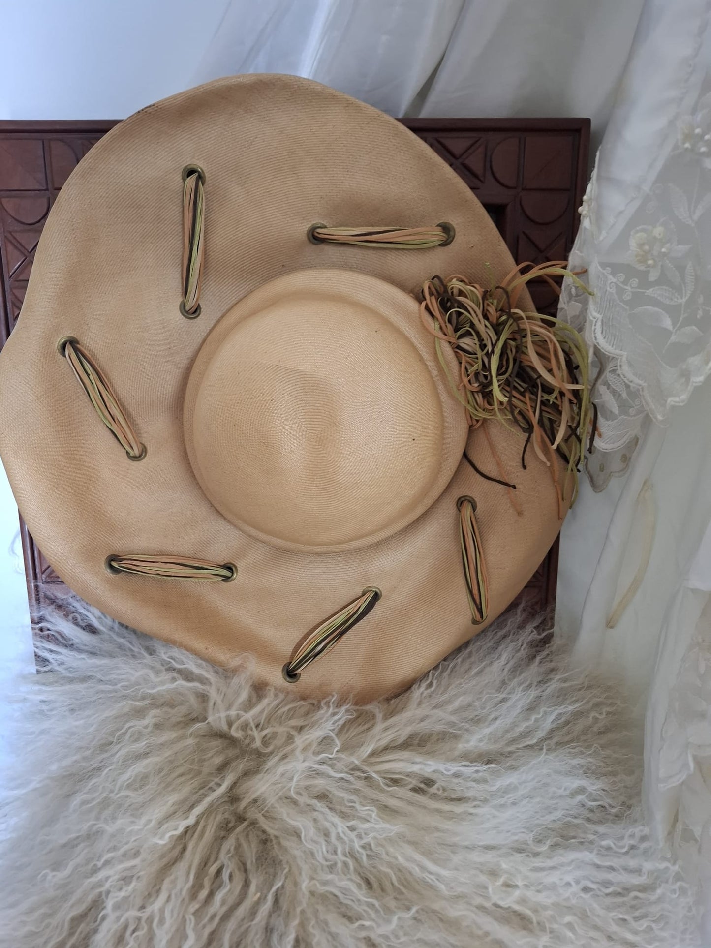 Ogilvie Natural Fibers & Earthy Flourish – With its wide curved brim, woven texture, and cascading green and brown ties, this beige beauty blends organic form with artful detail.