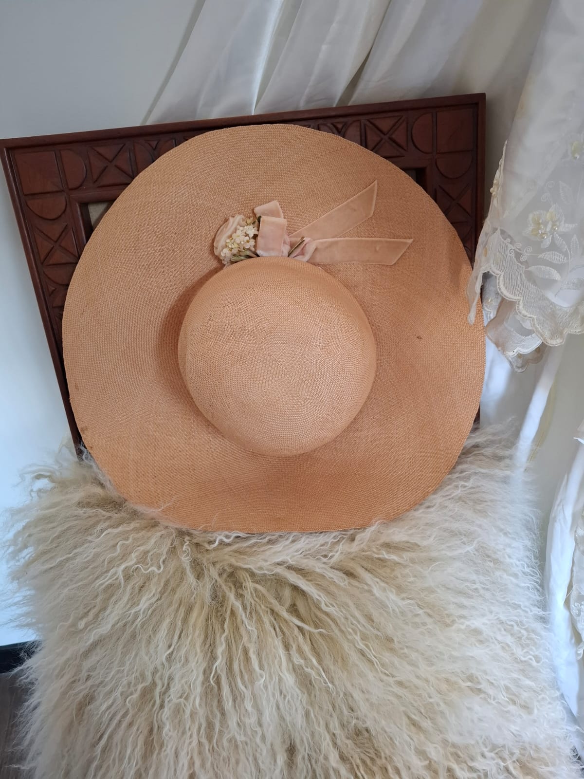Designed By Goullet of Melbourne Breezy Elegance- Featuring a sweeping brim and tall crown, this airy piece is adorned with a soft bow, floral accents, and delicate trims, capturing breezy elegance with a touch of whimsy.