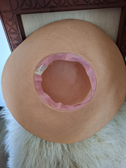 Designed By Goullet of Melbourne Breezy Elegance- Featuring a sweeping brim and tall crown, this airy piece is adorned with a soft bow, floral accents, and delicate trims, capturing breezy elegance with a touch of whimsy.