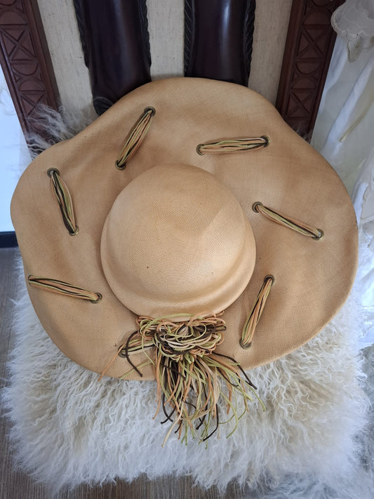 Ogilvie Natural Fibers & Earthy Flourish – With its wide curved brim, woven texture, and cascading green and brown ties, this beige beauty blends organic form with artful detail.