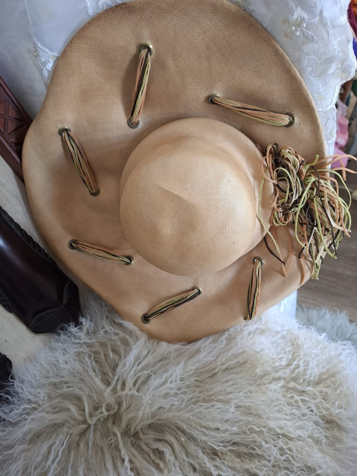 Ogilvie Natural Fibers & Earthy Flourish – With its wide curved brim, woven texture, and cascading green and brown ties, this beige beauty blends organic form with artful detail.