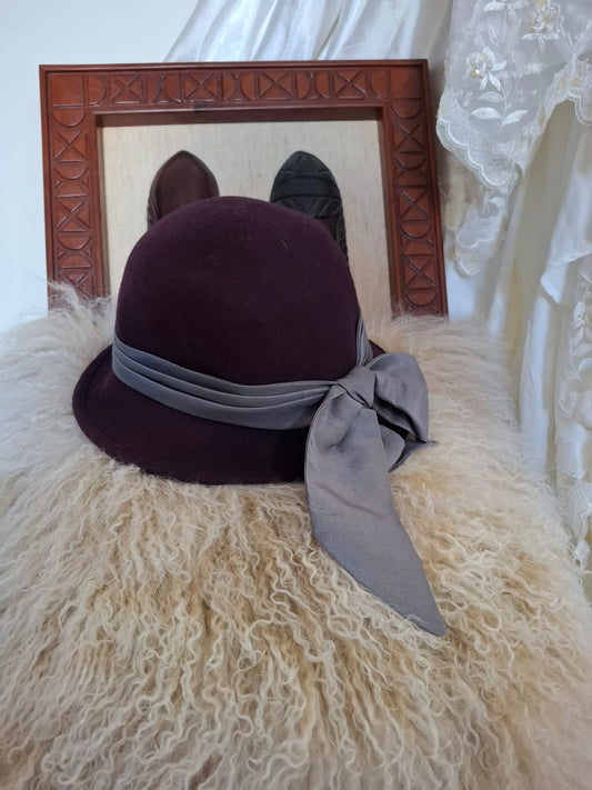 Goorin Bros Chic Refinement – A close-fitting silhouette with a gently curved brim, finished with a smooth, contrasting bow that adds a touch of grace and quiet drama.